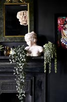 Classic bust on mantelpiece in black painted room 