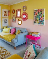Split colours on painted wall in colourful living room 