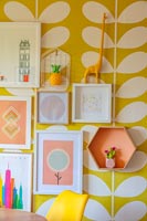 Pictures on wall with colourful patterned wallpaper 
