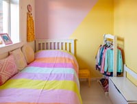 Blocks of differently coloured painted walls in modern childrens room 