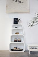 Stacked white shelves with display of nautical ornaments 