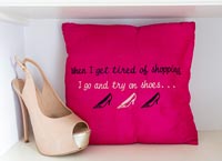 High heel sandal next to bright pink cushion