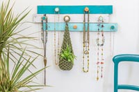 Wall hanging jewellery display unit made from painted timber strips and champagne corks 