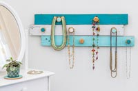Wall hanging jewellery display unit made from painted timber strips and champagne corks 