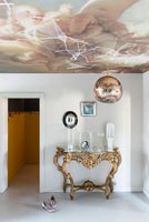 Ornate console table with lavish painted ceiling 