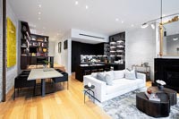 Modern open plan living space with kitchen, living, dining areas and small home office in corner
