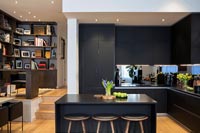 Modern open plan kitchen with view of raised home office in corner 
