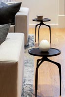 Detail of small black side tables in modern living room 
