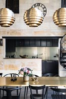 Black and gold modern dining room with view into kitchen 