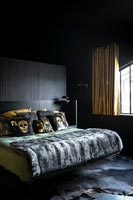 Modern bedroom with black walls and gold curtains 