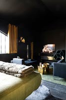 Modern bedroom with dark painted walls and gold accessories 