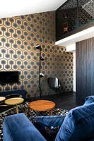 Black and gold wallpaper and seating area in modern bedroom 