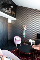 Black and gold patterned wallpaper in eclectic child's bedroom 