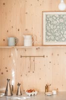 Accessories on kitchen worktop with wooden walls