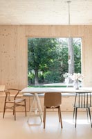 Modern timber clad country dining room with large picture window and views to garden