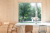 Modern timber clad dining room with large picture window over looking garden 