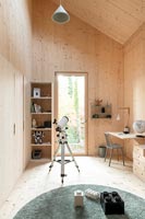 Timber clad modern children's room with telescope and desk