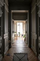 Panelled corridor with parquet flooring painted in dark colours 