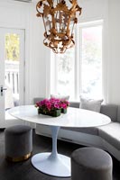 Oval white tulip table with built-in sofas and unusual pendant light 