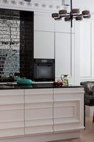 Large modern kitchen with island, tiled feature wall and period details 