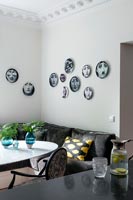 Wall display of decorative plates on dining area wall 
