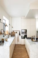 Modern white kitchen with parquet flooring 