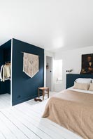 Modern bedroom with blue painted partition wall for wardrobe area