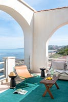 Archways on furnished terrace with carpet and sea views 