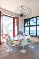 Modern dining room with sea views and open French windows leading to terrace 