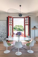 Modern dining room with view to terrace through open French doors 