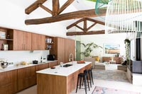 Exposed wooden beams over modern kitchen in open plan living space 