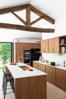 Exposed wooden beams over wood and white modern kitchen 