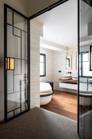 Contemporary bathroom seen through open Art Deco style internal doors 