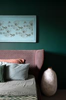 Pink upholstered headboard in green modern bedroom 