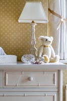 Lamp on white chest of drawers in classic style bedroom 