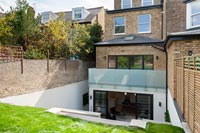 Exterior of house with modern basement extension and sunken terrace 