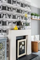 Patterned black and white wallpaper above fireplace in modern living room 