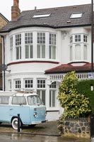 Campervan parked at front of classic semi-detached house 