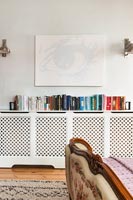 Large radiator cover with row of books on top 