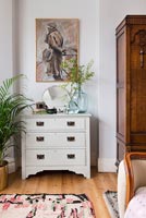 White vintage chest of drawers in bedroom 