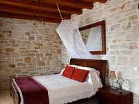 Exposed stone wall in country bedroom 