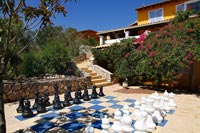 Large outdoor chess set on terrace next to Mediterranean style house 