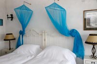 White country bedroom with blue canopies 