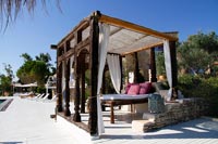 Decorative pergola with large bed on outdoor terrace 