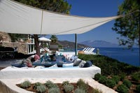 Outdoor dining table under sail shade with coastal views 