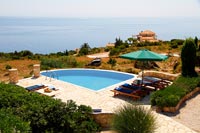 Overview of outdoor living area around swimming pool with sea view 
