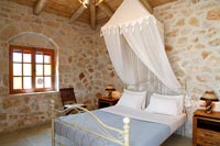 Exposed stone walls in country bedroom 