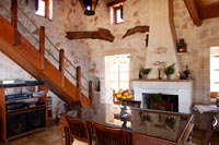 Country dining room with exposed wooden beams and stone walls 
