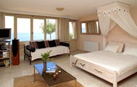 Modern country bedroom with canopy over bed and sea views 