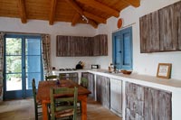 Country kitchen-diner with rustic wooden cabinets 